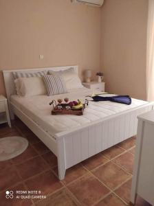 Una gran cama blanca con una bandeja de fruta. en LUXURY APARTMENT in front of the sea, en Kanali