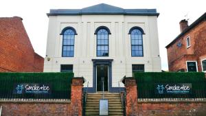 um edifício branco com janelas e escadas em frente em The Old Chapel Apartments em Edwinstowe