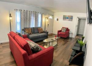 sala de estar con sofá rojo y sillas rojas en *King bed/3bds house Near Naval Base & 6Flags*, en Waukegan