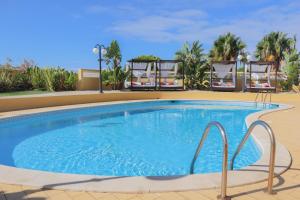 a swimming pool at a resort with chairs at Quinta Nova Vale Del Rey in Carvoeiro