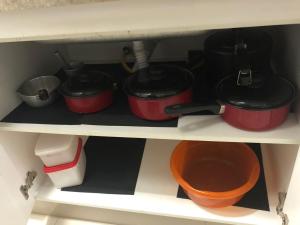 a shelf with three pots and pans and a bowl at CALDAS NOVAS - GO Apartamento Parque das Aguas Quentes bloco 3 - em frente Clube Privê in Caldas Novas