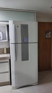 La cuisine est équipée d'un réfrigérateur blanc. dans l'établissement CALDAS NOVAS - GO Apartamento Parque das Aguas Quentes bloco 3 - em frente Clube Privê, à Caldas Novas