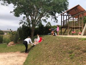 a group of people playing with a kite on a hill at Pousada Ecológica Espelho D'Água in Carrancas