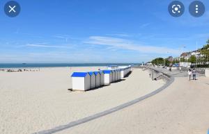 een strand met een rij strandhutten erop bij LE BALCON DE NOTRE DAME in Boulogne-sur-Mer