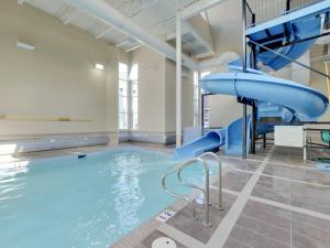 a swimming pool with a slide in a building at Sundance Suite - Beautiful Condo With Open Pool And Hot Tub in Canmore