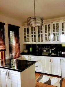 a kitchen with white cabinets and black counter tops at Villa Defne in Tekirdağ