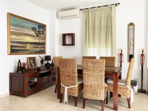 uma sala de jantar com uma mesa de madeira e cadeiras em Casa ChillOut a 6km de Sevilla Piscina comunitaria em Valencina de la Concepción