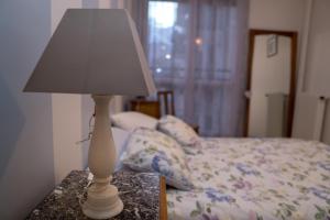 eine weiße Lampe auf einem Tisch neben einem Bett in der Unterkunft EXIGEHOME Grand T2 proche Paris Porte d'Orléans in Châtillon