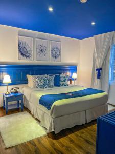 1 dormitorio con 1 cama grande con detalles en azul en Flame Hotel Boutique Canela, en Canela