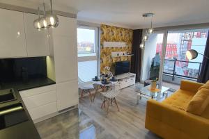 kuchnia i salon z kanapą i stołem w obiekcie Apartament3City w Gdańsku