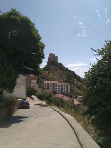 un edificio en una colina con un castillo encima en Casa Concha, en Alcalá de la Selva