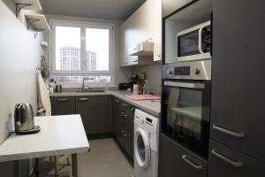 a kitchen with a microwave oven and a washer and dryer at EXIGEHOME Grand T2 proche Paris Porte d'Orléans in Châtillon