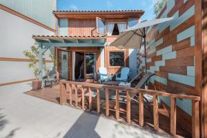 ein Haus mit einer Terrasse mit Stühlen und einem Sonnenschirm in der Unterkunft Las Hermanas B in Guía de Isora
