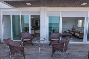 a patio with chairs and a table and a living room at Casa beira mar na Praia da Redinha by Qavi in Natal +22 photos