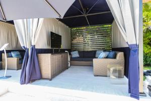 patio z kanapą i krzesłami pod namiotem w obiekcie Anna Maria Beach Resort w mieście Holmes Beach