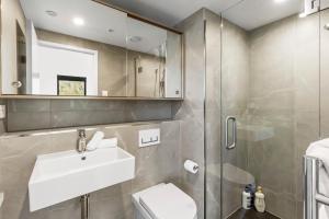 a bathroom with a sink and a toilet and a shower at Riverview Penthouse - Apartment 19 in Queenstown