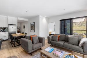 uma sala de estar com dois sofás e uma mesa em Riverview Penthouse - Apartment 19 em Queenstown