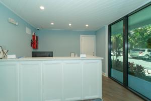 a kitchen with white cabinets and a large window at Anna Maria Beach Resort in Holmes Beach