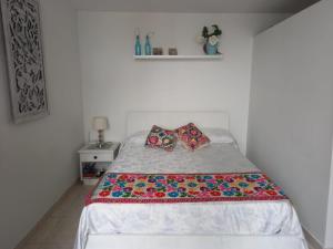 um quarto com uma cama com duas almofadas em Hermoso apartamento frente al Mar Caribe em Cartagena das Índias