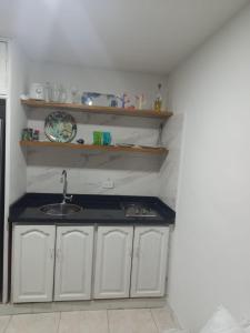 uma cozinha com armários brancos, um lavatório e prateleiras em Hermoso apartamento frente al Mar Caribe em Cartagena de Indias