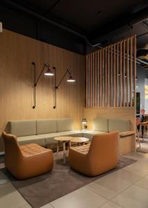 a lobby with a couch and tables and chairs at Comfort Hotel Xpress Youngstorget in Oslo