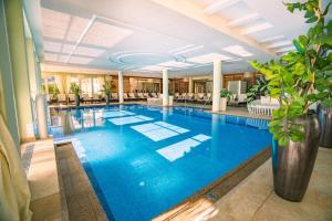 duży basen z błękitną wodą w holu w obiekcie Grandhotel Lienz Business-Wellness & Gourmet w mieście Lienz