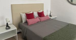 sypialnia z łóżkiem z białymi i czerwonymi poduszkami w obiekcie Amilcar Cabral Loft w mieście Praia