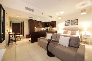 a living room with a couch and a kitchen at Prime Retreats - Downtown Dubai in Dubai