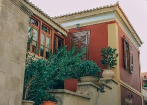 Una casa con macetas al costado. en Aeginitikon Arhontikon Stylish Boutique Hotel en Aegina Town
