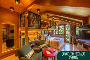 a living room with a bed and a table and chairs at Hotel Alpestre in Gramado