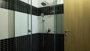 a bathroom with a shower with black and white tiles at Eka Luxury Two-Bedroom Penthouse in Durrës