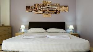 a bedroom with a large white bed with two lamps at Eka Luxury Two-Bedroom Penthouse in Durrës