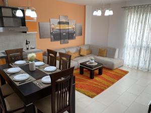 ein Wohnzimmer mit einem Tisch und einem Sofa in der Unterkunft Eka Luxury Two-Bedroom Penthouse in Durrës