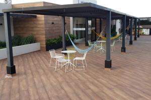 un patio con hamaca, mesas y sillas en Monoambiente de Lujo en Zona Premium Equipetrol, en Santa Cruz de la Sierra