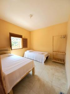 a bedroom with two beds and a window at Casa DeTe Caldas-Barbalha in Barbalha