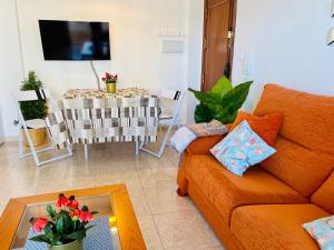 sala de estar con sofá y mesa con TV en Apartamento, Sol y Playas, en Benalmádena