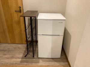 a white refrigerator next to a table in a room at Koya TRIBE - Vacation STAY 83398v in Oishi