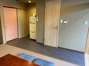 a room with a refrigerator and a table and blue tiles at Koya TRIBE - Vacation STAY 83064v in Oishi