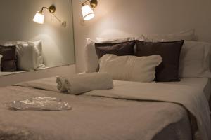 1 cama blanca grande con almohadas y espejo en Paris Lady Mimi en París