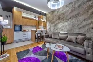a living room with a couch and a kitchen at Apartments Mons in Vila Katalina in Zlatibor