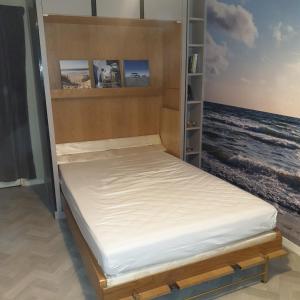 a bed in a room with a view of the ocean at Appartement studio proche mer 4 pers résidence calme avec parc in Blonville-sur-Mer