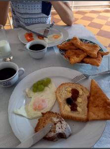 um prato de pequeno-almoço com pão de ovos e batatas fritas em Hotel Vila Nino em Berat