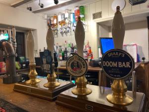 een bar met drie glazen flessen op een aanrecht bij The Plough Inn Boddington in Daventry