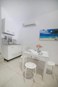 eine weiße Küche mit einem weißen Tisch und Stühlen in der Unterkunft Casa Carmela in Neapel