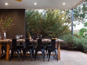 a wooden table and chairs sitting on a patio at Manna Gums in Daylesford