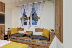 a bedroom with a bed and two windows at Riverside Inn - dunaparti szuterén in Győr