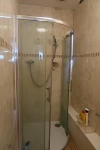 a bathroom with a shower with a glass door at Spacious 4 bed Farnborough AirShow in Blackwater