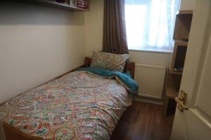 a small bedroom with a bed and a window at Spacious 4 bed Farnborough AirShow in Blackwater