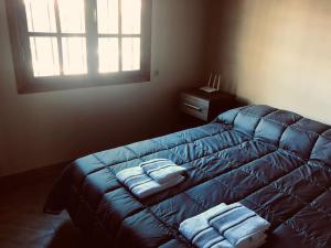 a bedroom with a blue bed with towels on it at Cabañas Villa Alicia in Potrerillos