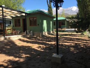 a green building with a light pole in front of it at Cabañas Villa Alicia in Potrerillos